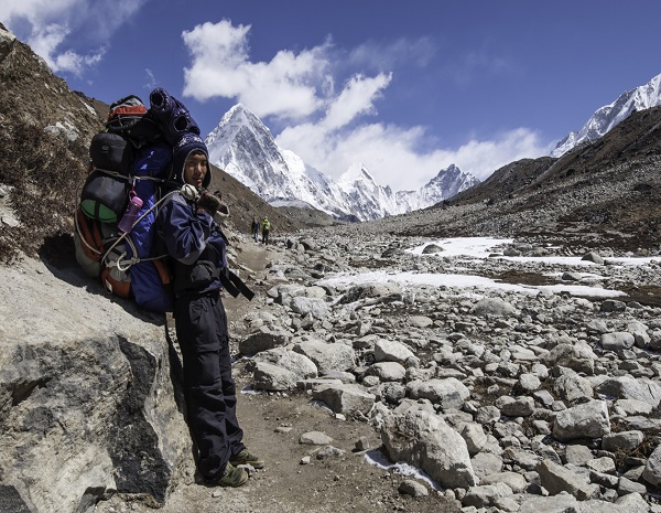 Sherpa carrying expedition kit Himalaya mountain peak Nepal